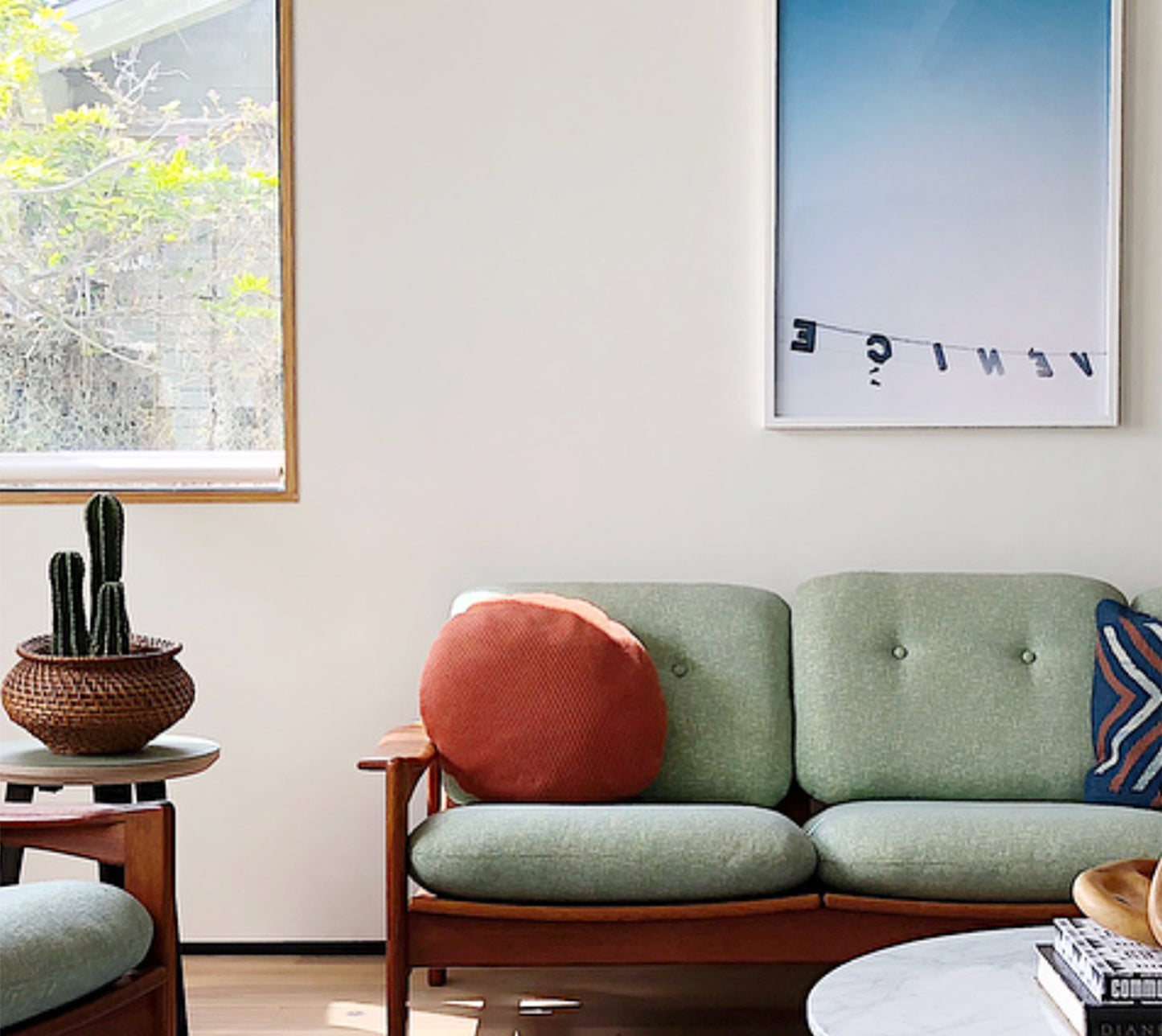 BACKWARDS photograph of reversed Venice sign with ombré sky hung in modern light-filled living room.