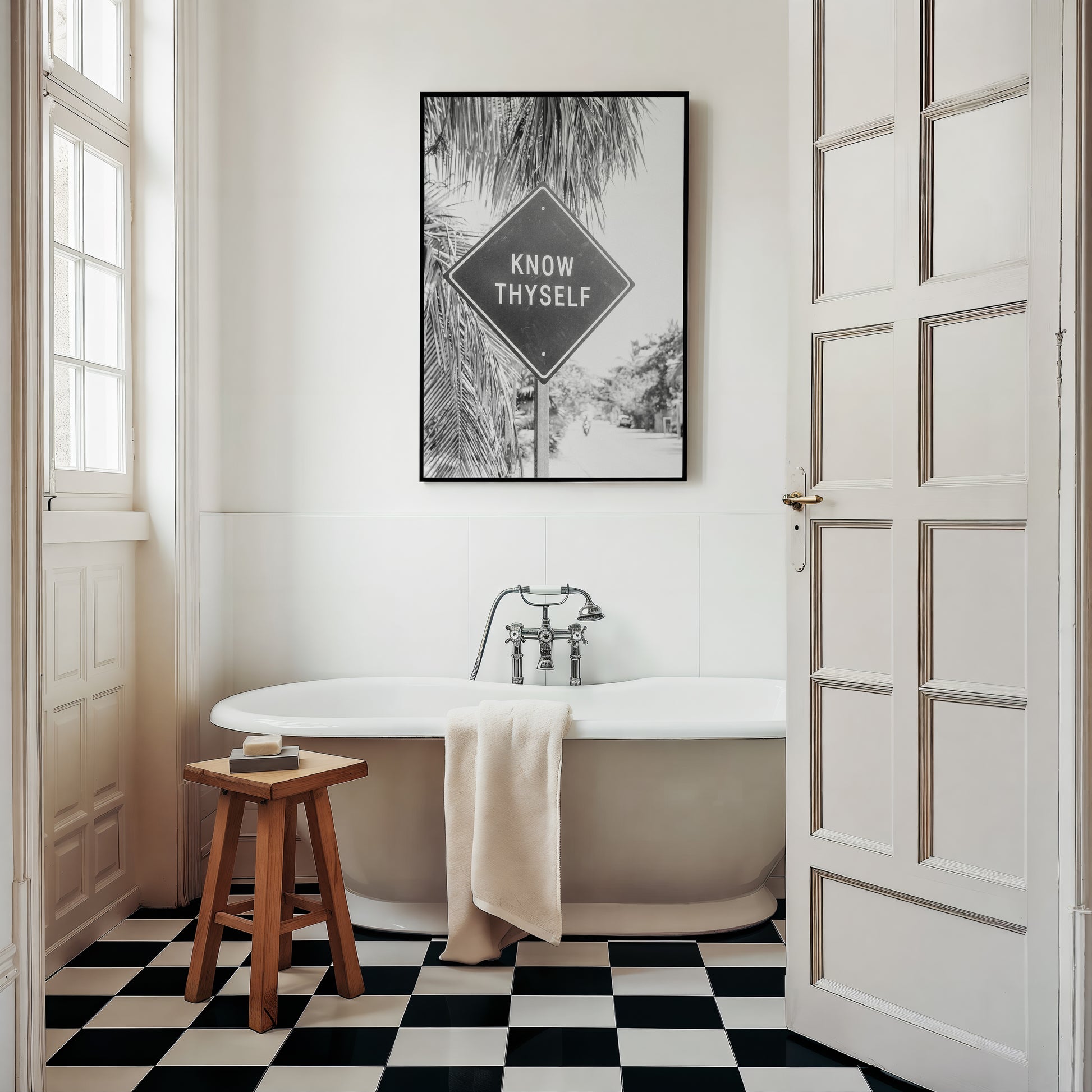 KNOW THYSELF black-and-white Tulum road sign art print in minimalist bathroom with palm trees and checkerboard floor.