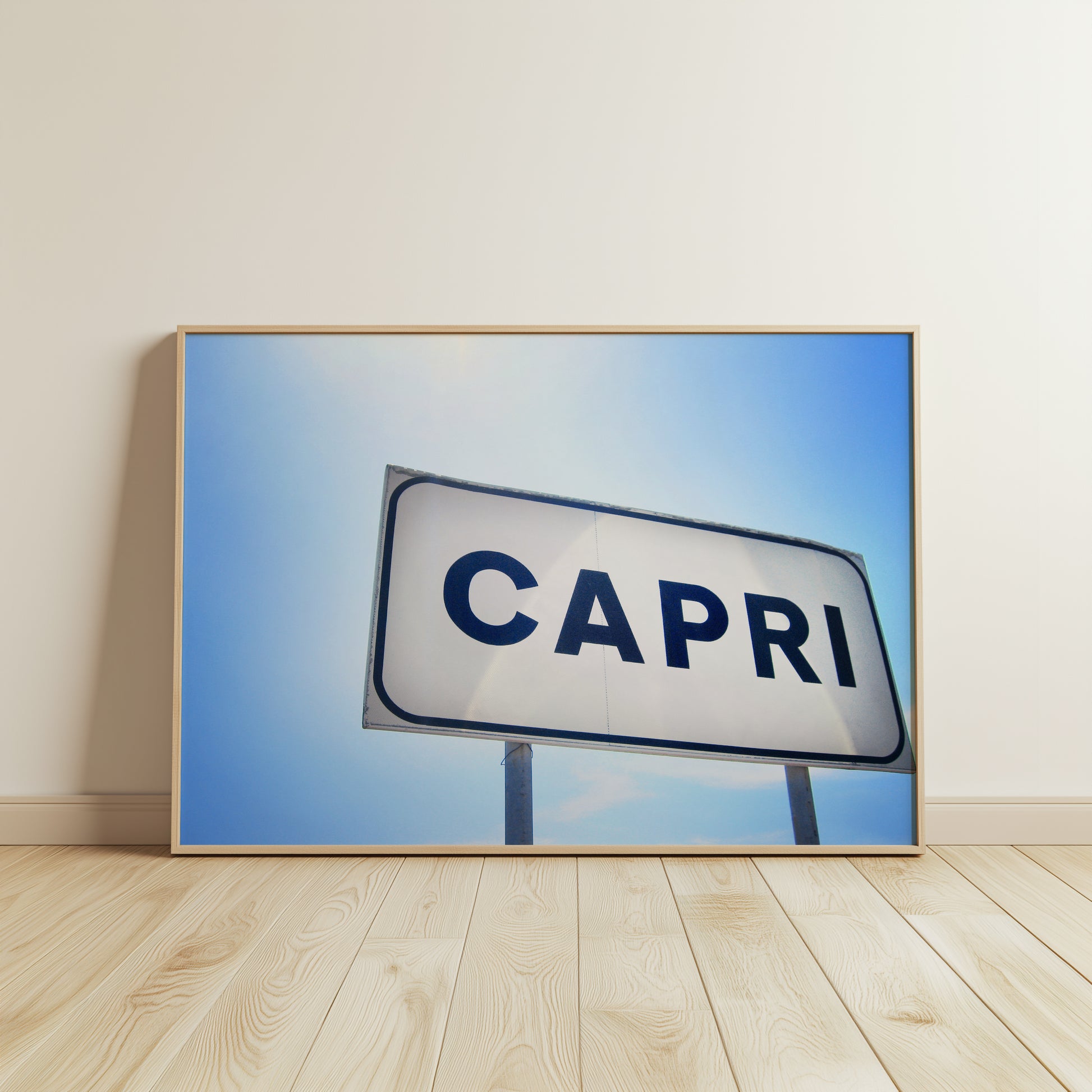 CAPRi product showing a minimalist sign against a clear blue Mediterranean sky, evoking Italian summer vibes and travel.
