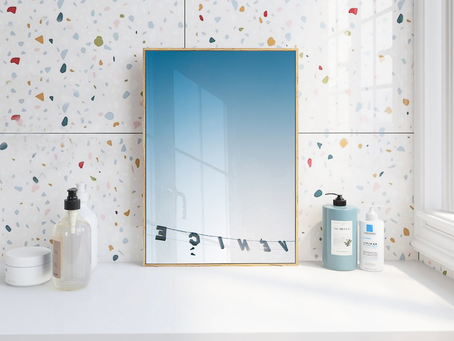 BACKWARDS art print showing Venice sign reversed against a clear blue sky in a modern bathroom setting.