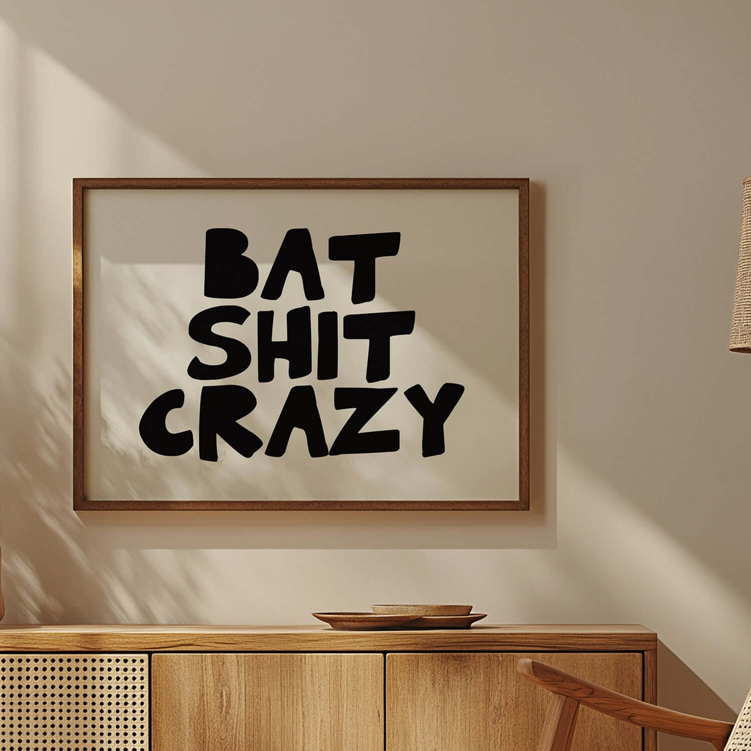 Black and white poster with chunky hand-lettered typography reading BAT SHiT CRAZY in a modern room setting.