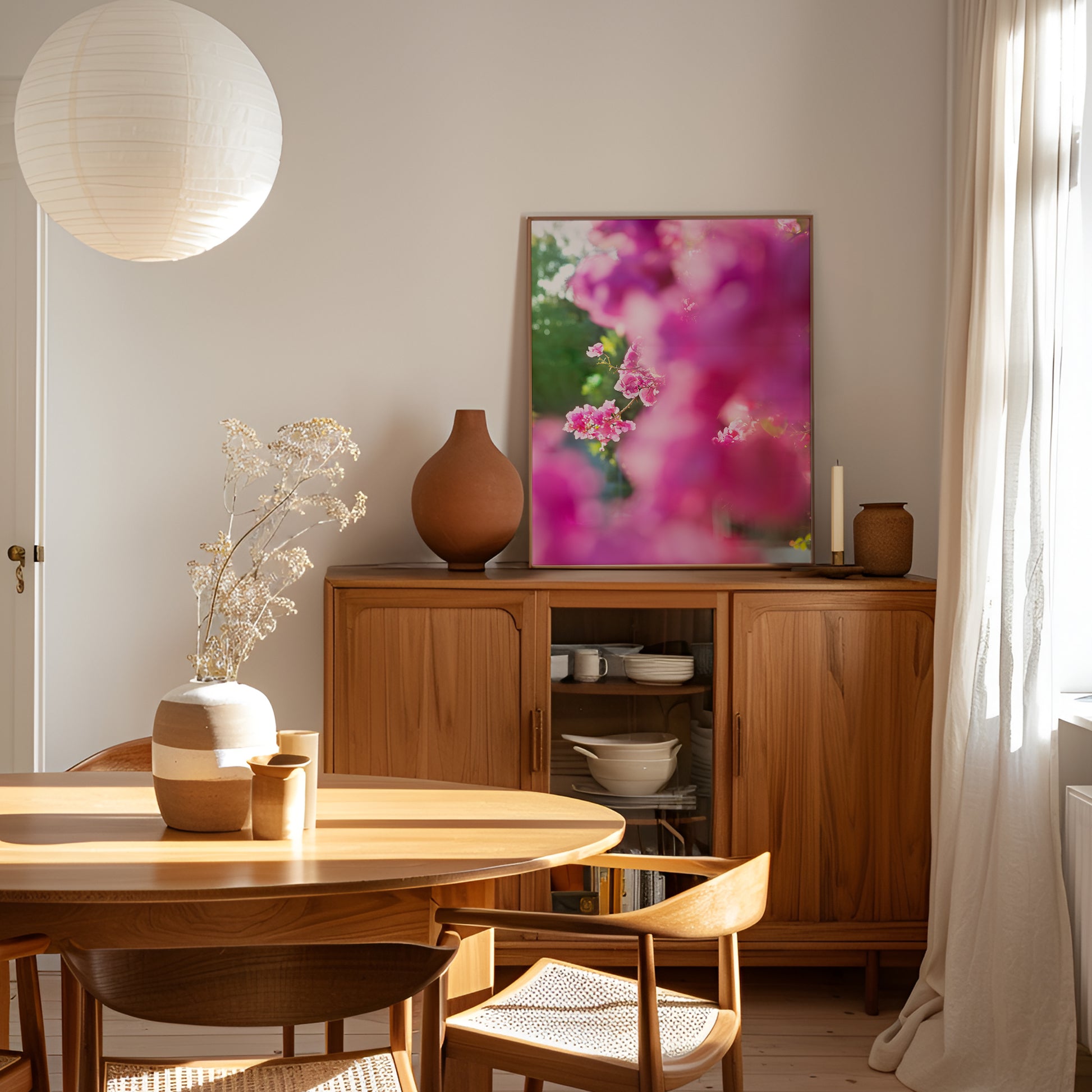 BEACHWOOD BOUGAiNViLLEA print featuring pink bougainvillea florals in golden sunlight, framed in a cozy modern dining room.