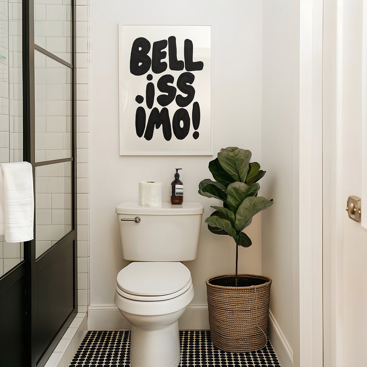 BELLiSSiMO! black & white poster with bold typography above toilet in modern bathroom with plant and shower door