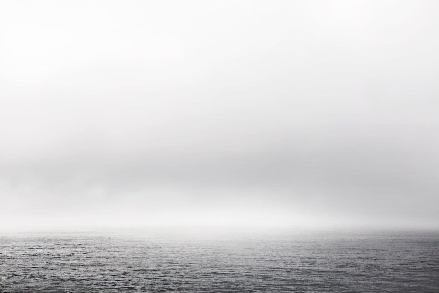Black and white ocean view with fog and gentle waves – minimalist seascape photography