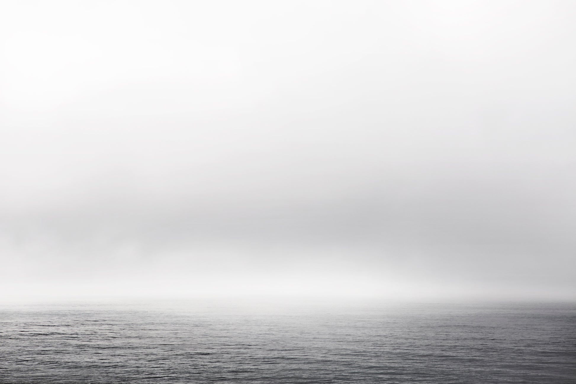 Black and white ocean view with fog and gentle waves – minimalist seascape photography