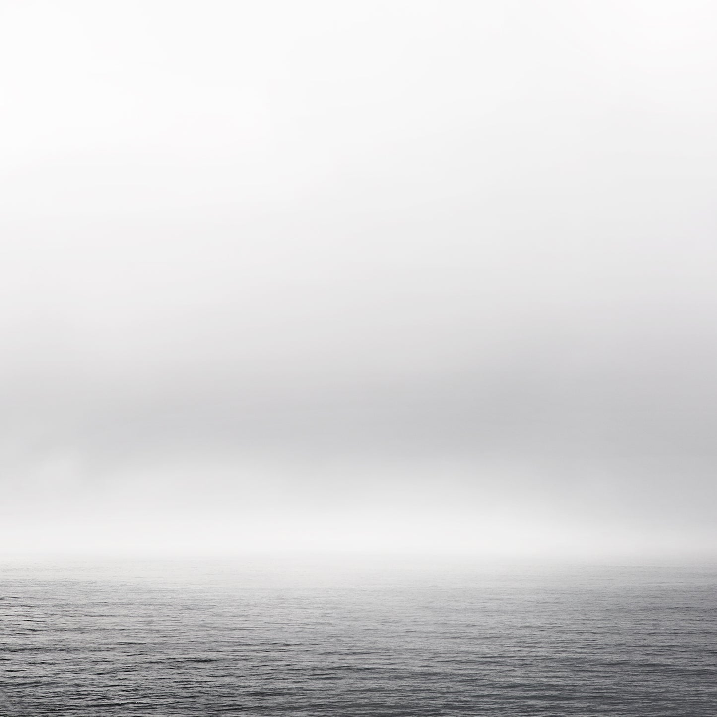 Black and white ocean view with fog and gentle waves – minimalist seascape photography