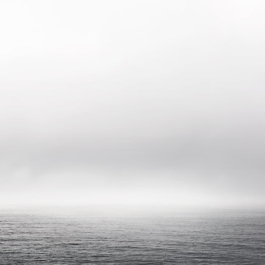 Black and white ocean view with fog and gentle waves – minimalist seascape photography