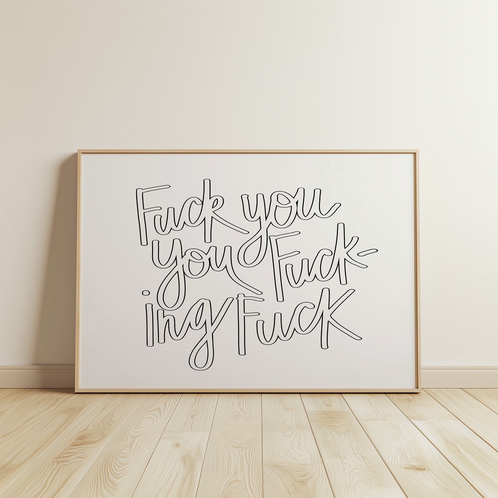 Framed black and white hand-lettered poster titled "FUCK YOU YOU FUCKING FUCK" displayed on wooden floor against white wall.