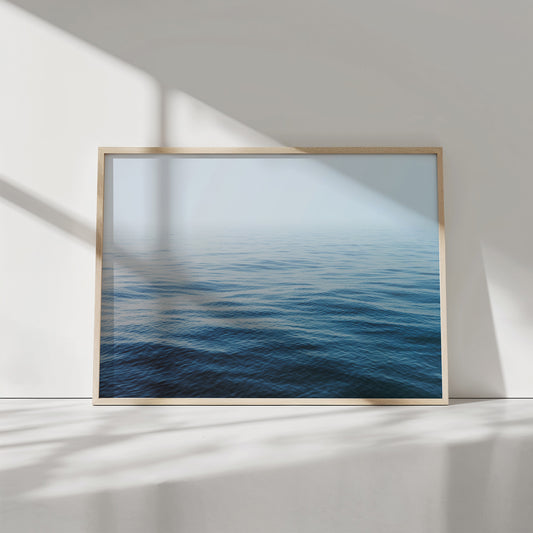 Framed minimalist ocean print titled HER MAJESTY showing calm blue and turquoise endless horizon for serene interiors.
