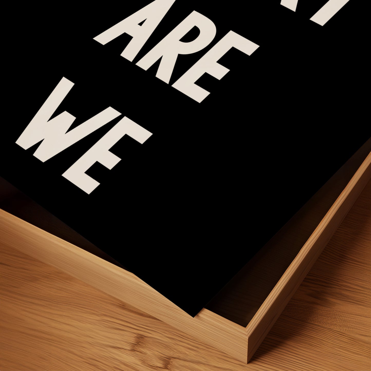 Close-up of black-and-white typography poster titled HOW LUCKY ARE WE with minimalist design on wooden surface.