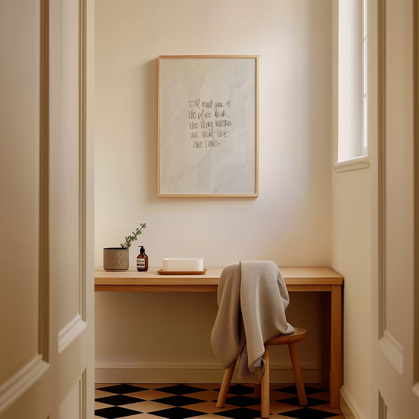 Framed "I'LL MEET YOU AT THE PLACE ..." poster in a cozy room with wooden desk and chair draped with a blanket.