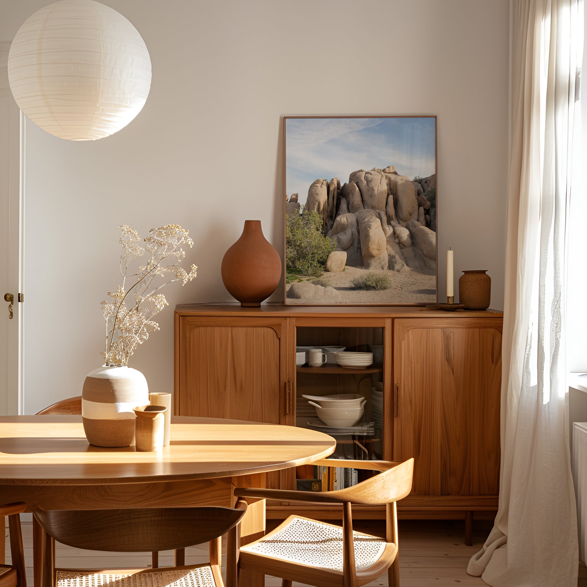Joshua Tree 2002 framed photo of desert rock formations in warm sunlight displayed in a minimalist dining room.