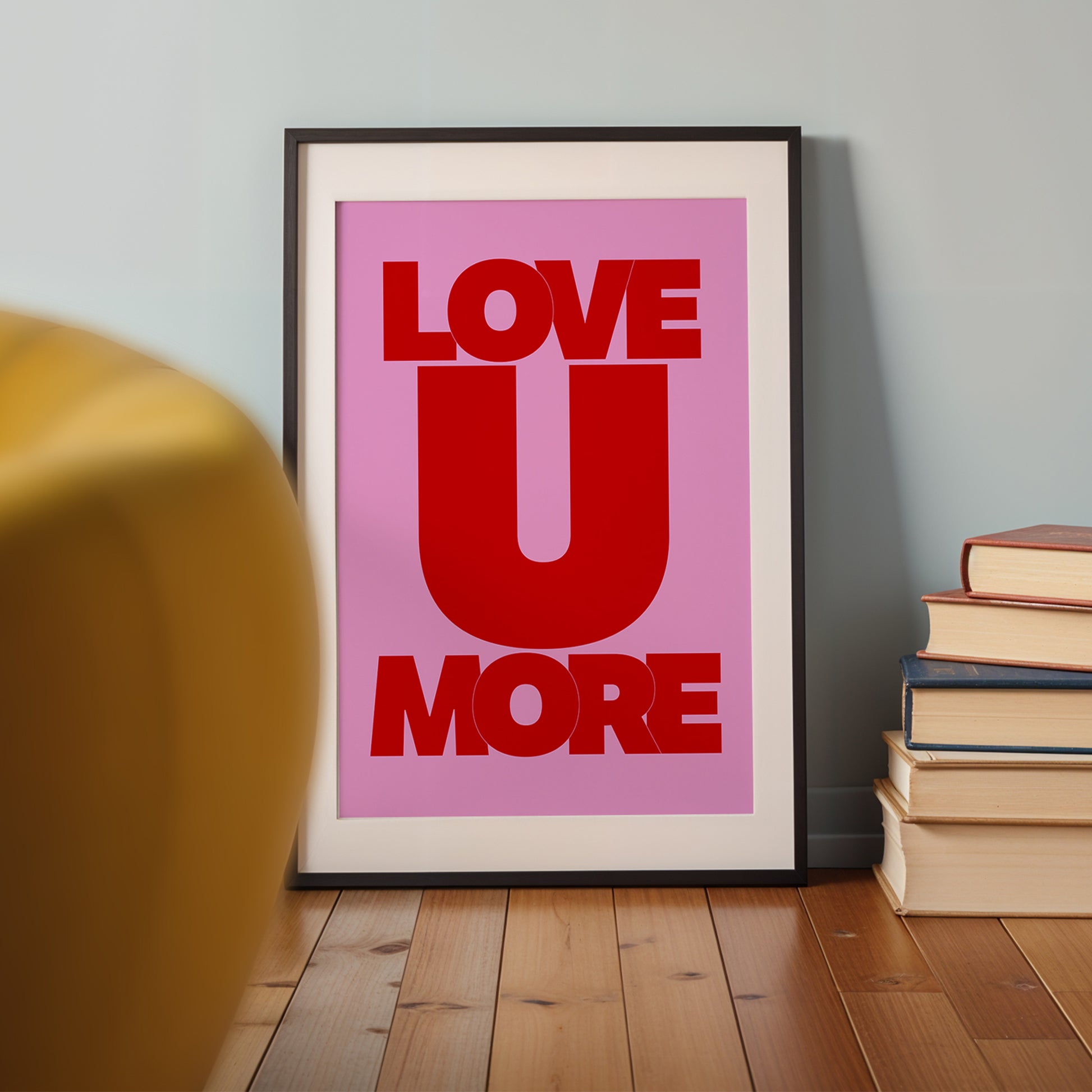 LOVE U MORE poster with bold red typography on vibrant pink background, perfect for brightening any room or gifting.