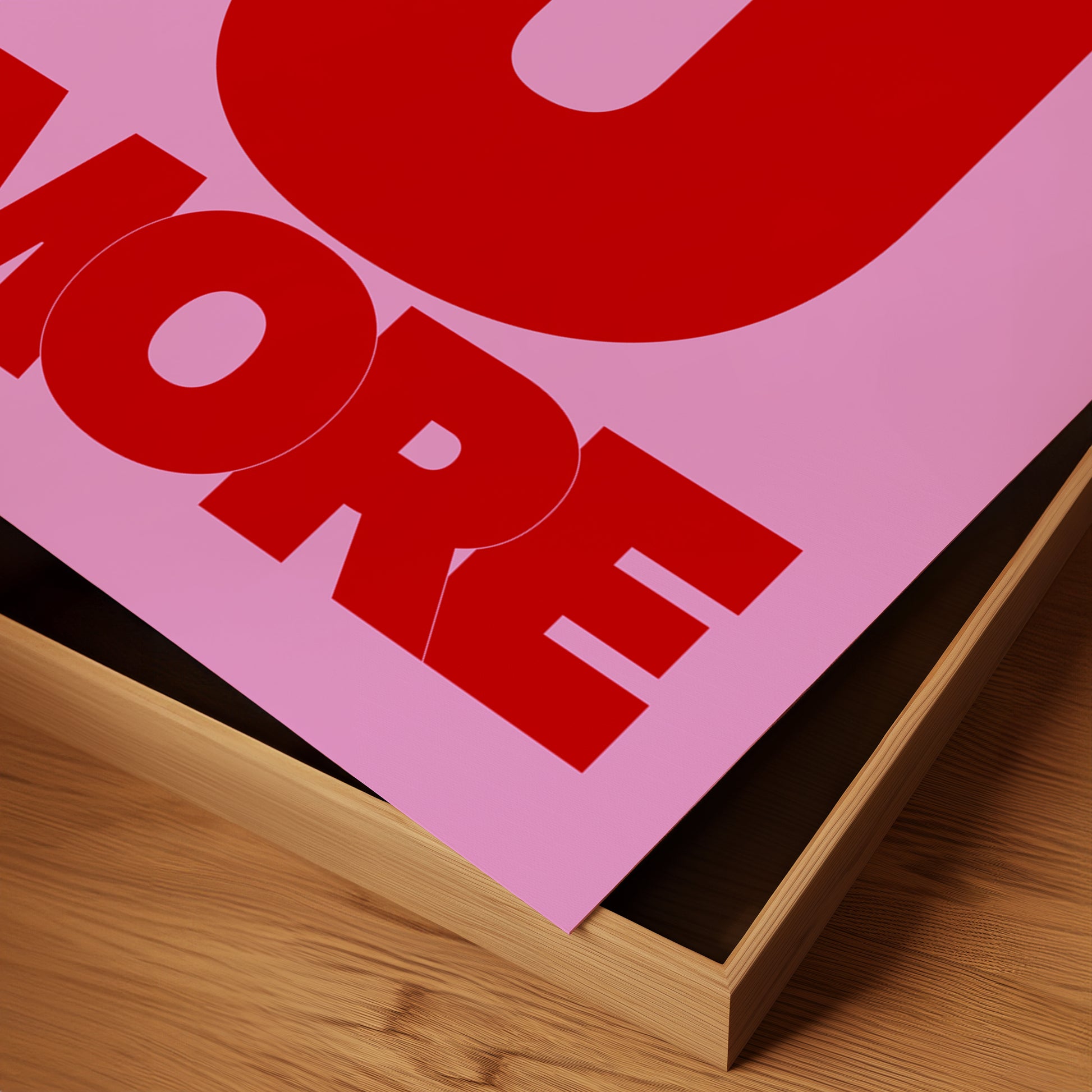 Close-up of the "LOVE U MORE" poster with bold red typography on vibrant pink matte paper.
