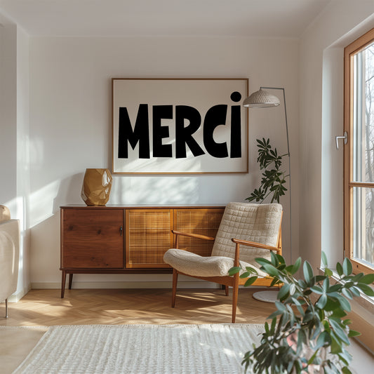 MERCi poster with bold black and white typography displayed in a modern living room with natural light.