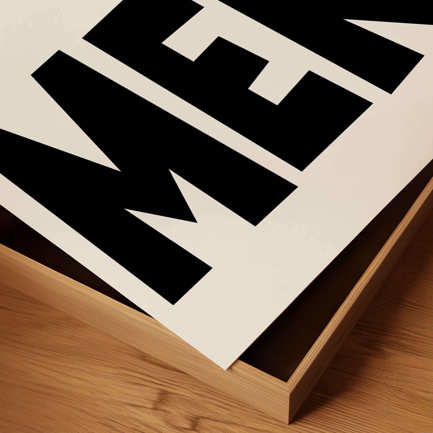Close-up of bold black and white typography print poster titled MERCi on textured matte paper in wooden frame.