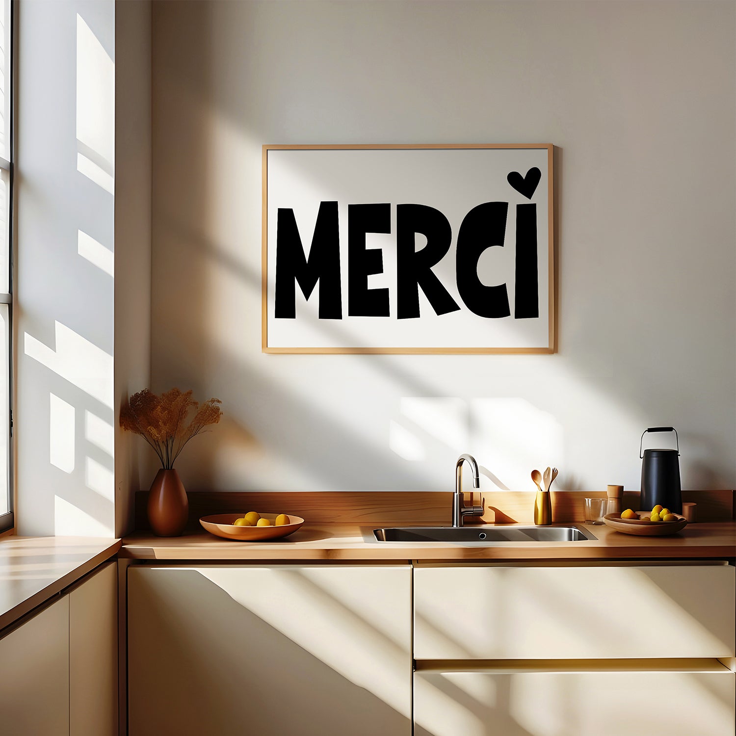 MERCi poster with bold black typography and heart detail hanging in a bright kitchen space with modern decor.