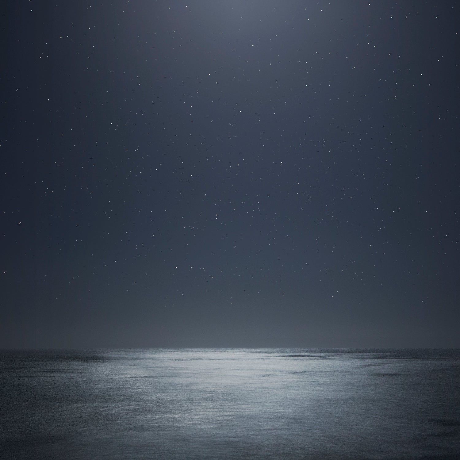 MiDNiGHT serene starry night sky over moonlit sea with soft reflections in black and grey tones.