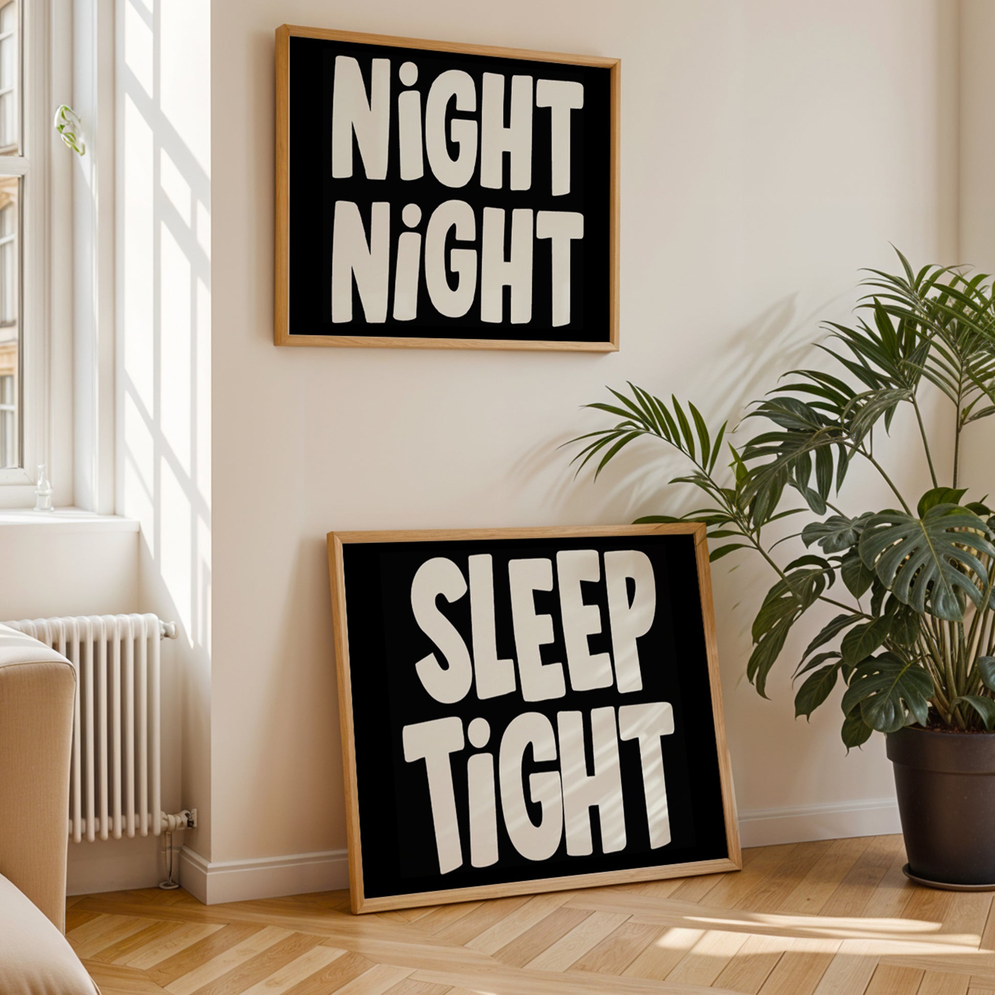 Framed NiGHT NiGHT poster with oversized handwritten white letters on black wall, styled in cozy modern room.