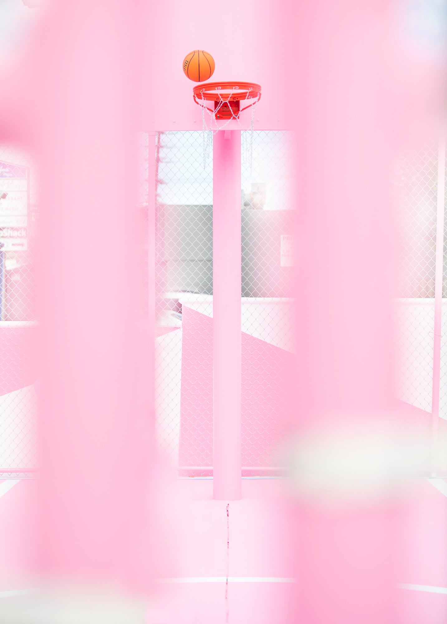 PiNK HOOPS shows an orange basketball above a bright pink basketball hoop on a vibrant court.