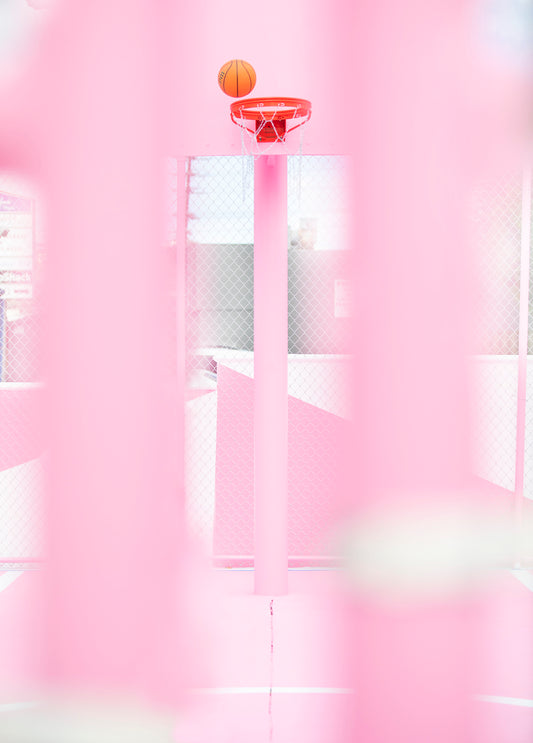 PiNK HOOPS shows an orange basketball above a bright pink basketball hoop on a vibrant court.