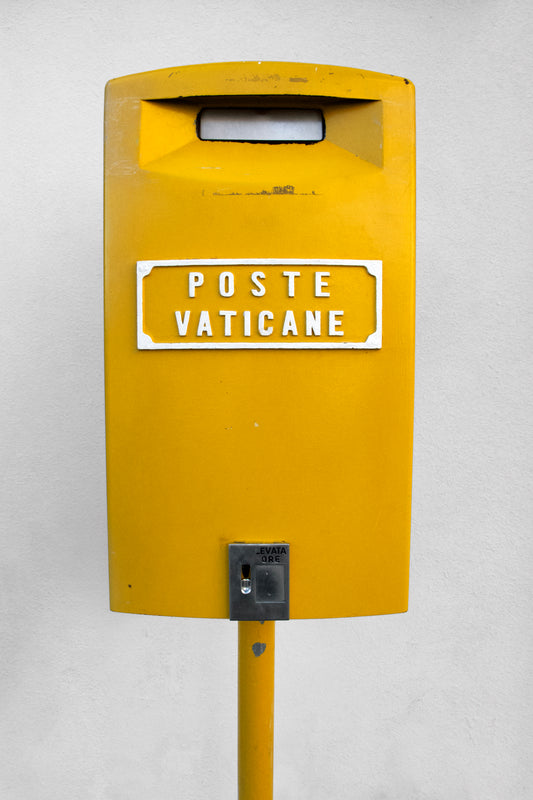 POSTE VATiCANE yellow Vatican City mailbox photographed with minimalist design and vintage typography on white background.