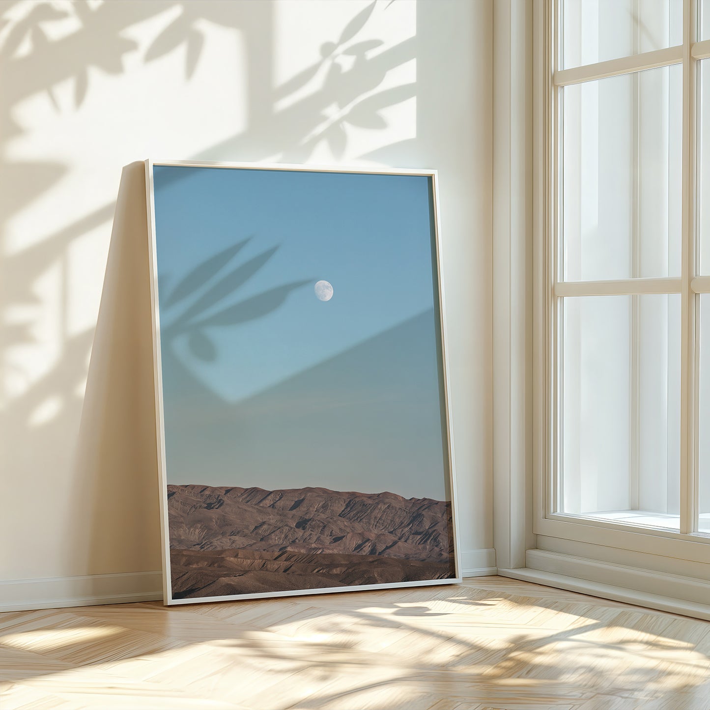 RiSiNG print of moon rising above desert mountains under a clear blue sky, perfect for calming interiors.
