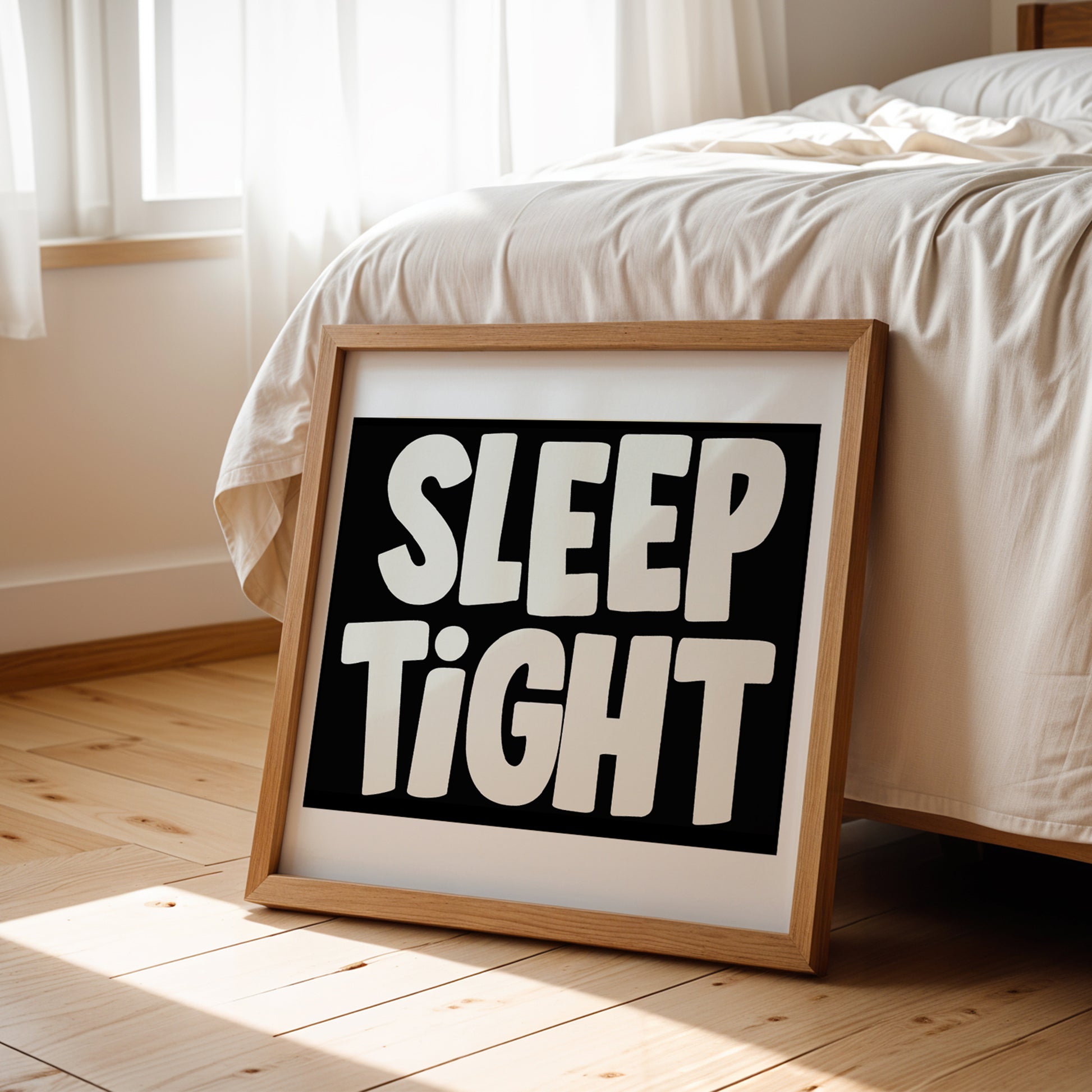 Framed SLEEP TiGHT poster with bold black-and-white typography leaning against a cozy bed in a sunlit bedroom.