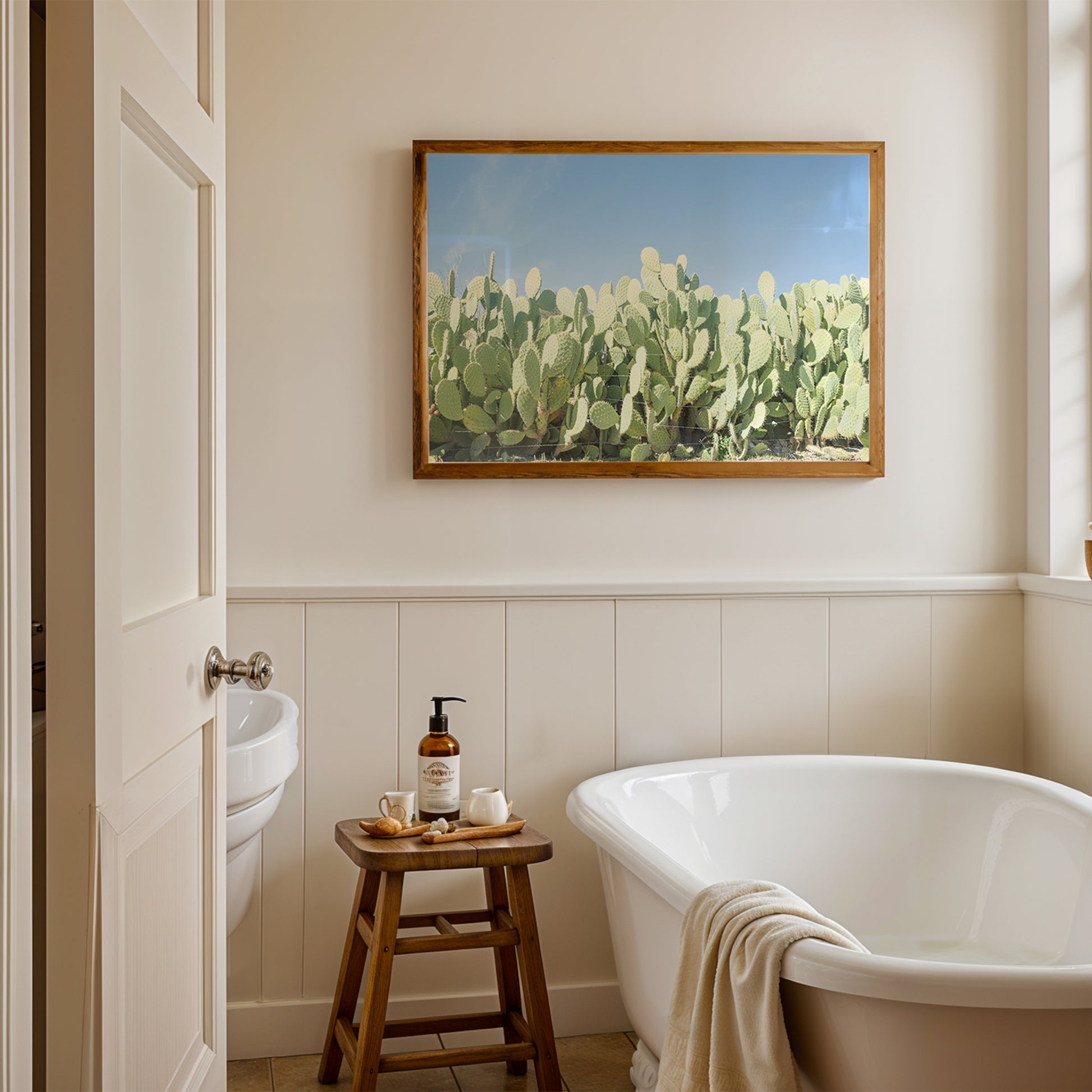 SUGAR SUGAR product showing cactus print above bathtub in a modern, minimalist bathroom with natural light.