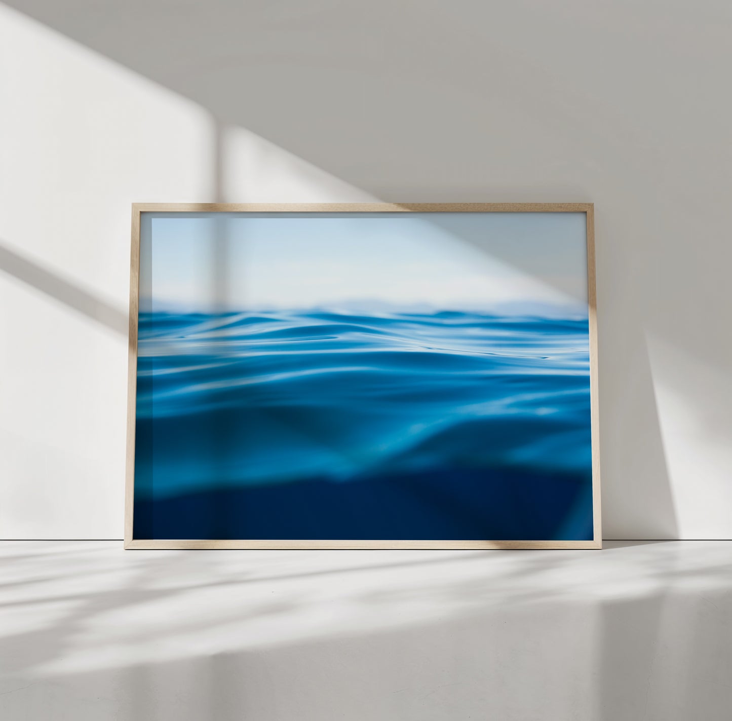 Framed minimalist water art titled TAHOE BLUE showcasing deep blue waves on matte photo paper in natural light.