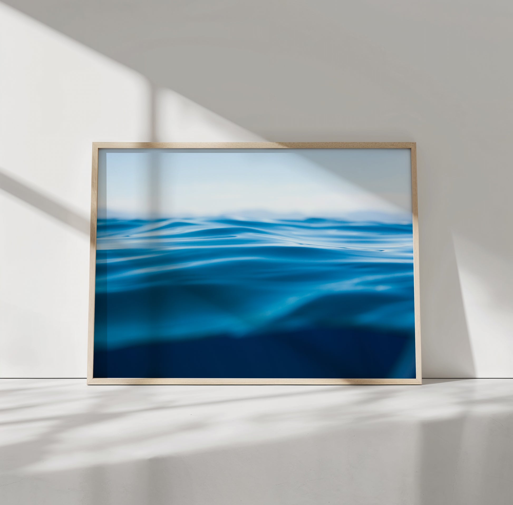 Framed minimalist water art titled TAHOE BLUE showcasing deep blue waves on matte photo paper in natural light.