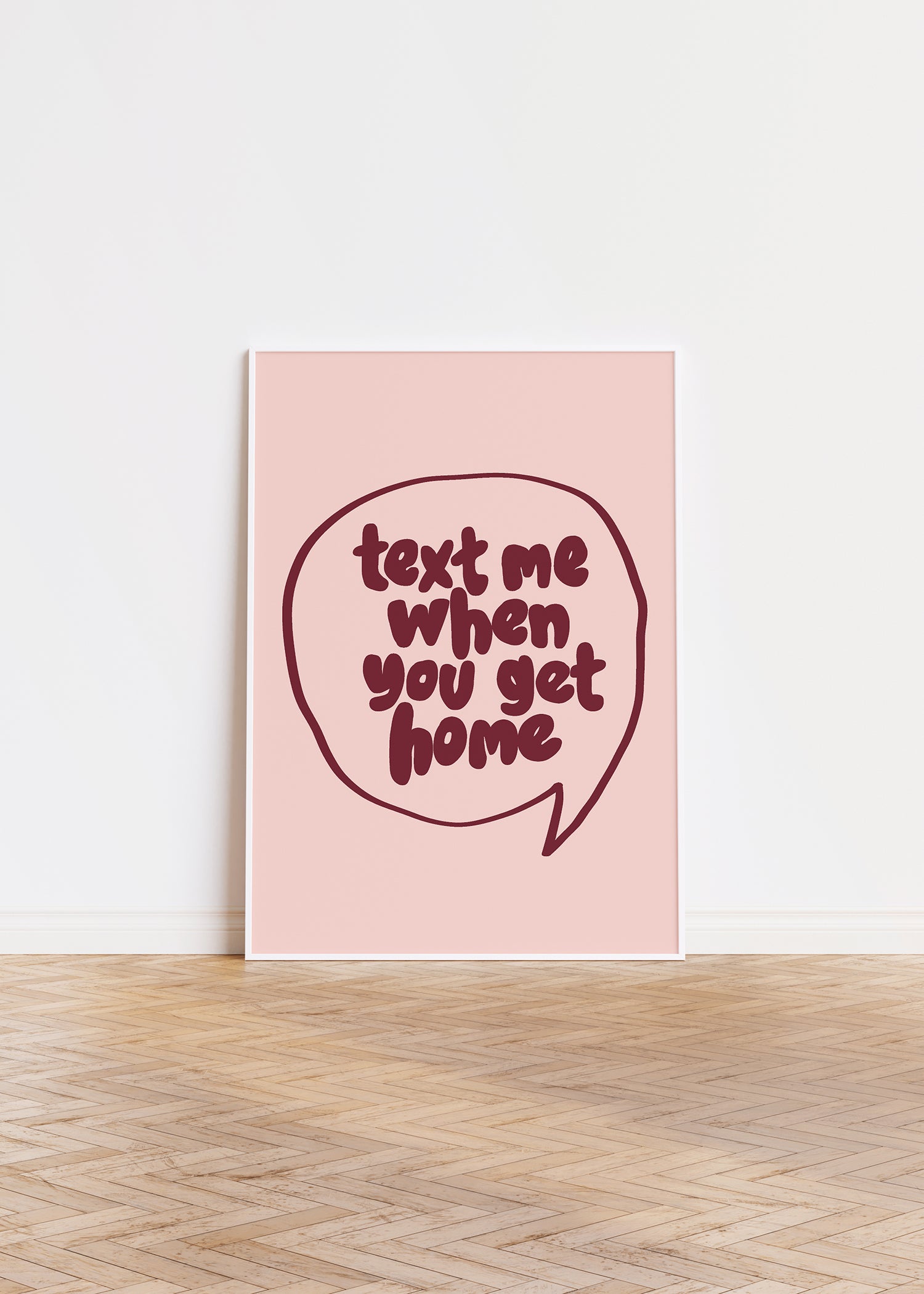 TEXT ME WHEN YOU GET HOME" poster with bold burgundy hand-drawn lettering in a speech bubble on blush background.