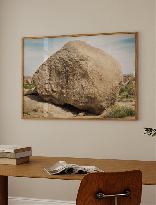 Framed desert photograph titled THE ROCK showing a massive sculptural boulder in natural light on a minimalist wall.