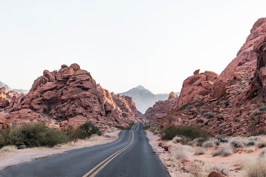 THE ROAD showing a winding desert road through red rock formations evoking calm, adventure, and southwest earth tones.