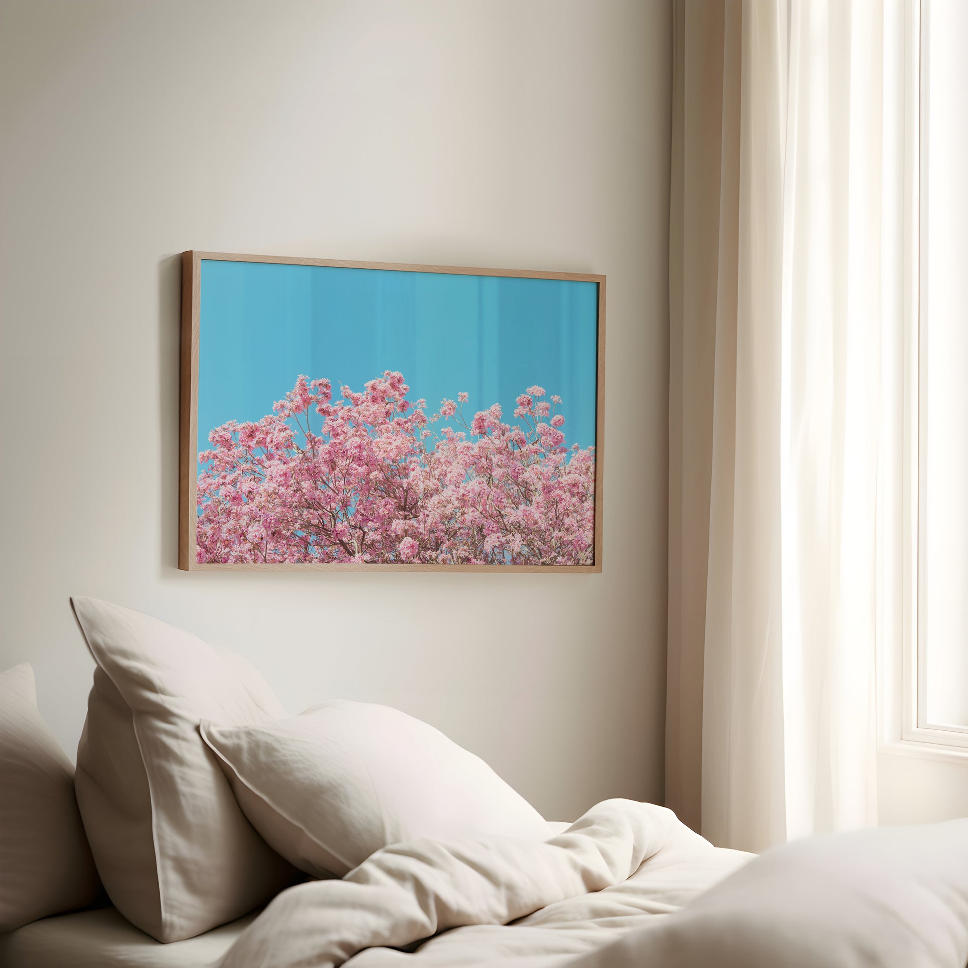 ViLLAGE BLOOM framed art showing vibrant pink blossoms against a bright cyan sky in a cozy, light-filled room.