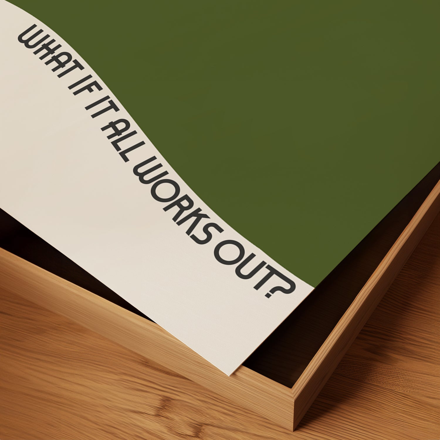 Minimalist matte poster titled WHAT iF iT ALL WORKS OUT with wavy text and bold olive green waves on wood surface.