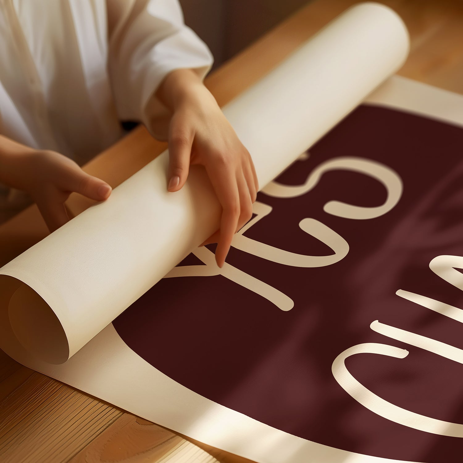 Person unrolling a maroon and cream "YES CHEF!" poster on a wooden surface for kitchen decor.