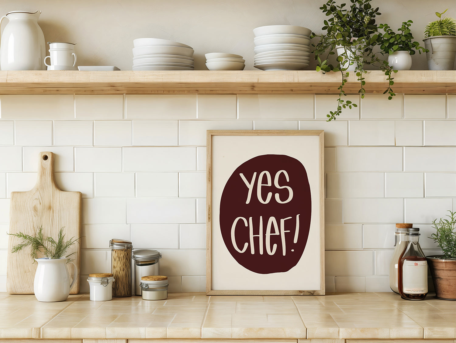 YES CHEF! poster in maroon and cream displayed in a modern kitchen with white tiles and wooden shelves.