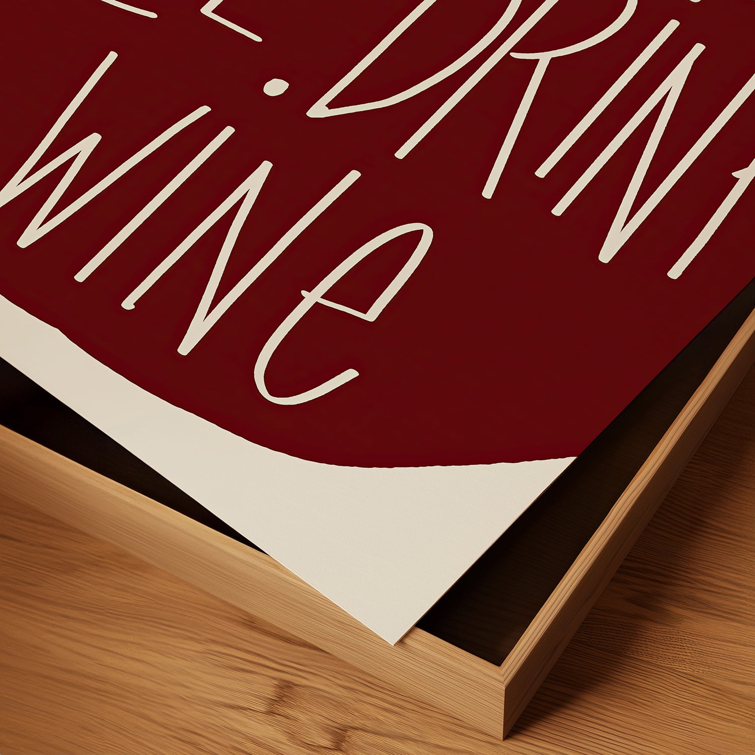 Close-up of "YOU COOK I'LL DRINK WiNE" poster in burgundy red, perfect cheeky kitchen wall art for wine lovers.