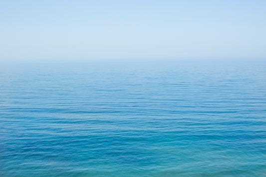 YOU ARE SMALL minimalist ocean print showing calm turquoise and blue sea meeting soft blue sky on the horizon.