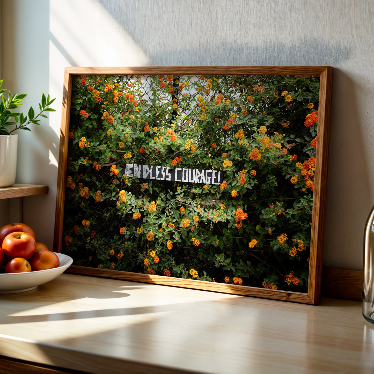 Framed "ENDLESS COURAGE" art print with vibrant orange and yellow flowers on a chain-link fence, bright and bold.