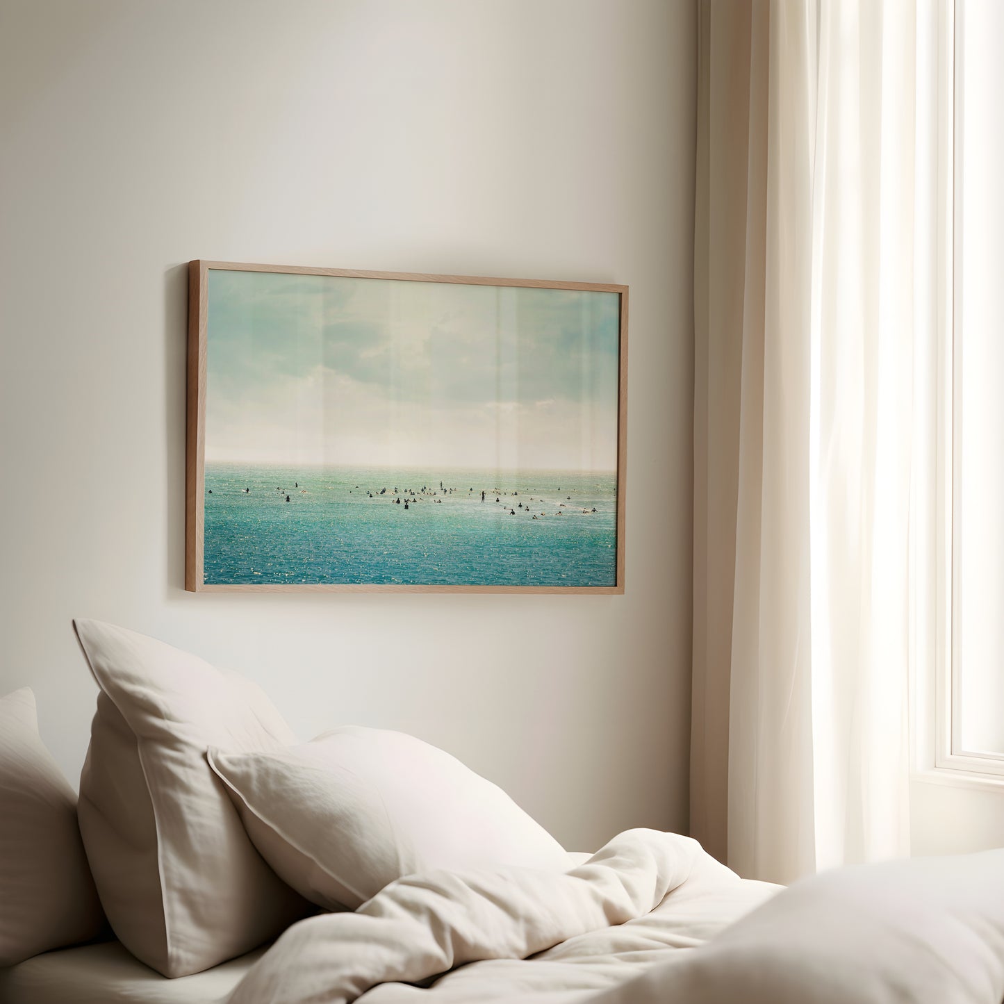 SURFRiDER ocean photo wall art showing surfers waiting in turquoise water under moody skies in a serene coastal setting.