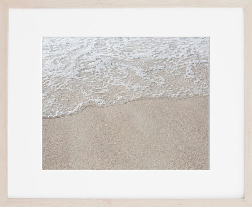 A minimal image of crystal clear water washing upon the sand