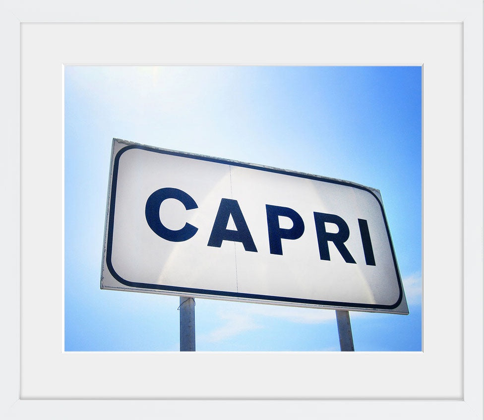 A minimal and modern image of the town sign in Capri, Italy against a blue sky streaked with sunlight. Available in square and horizontal formats in small and medium sizes. Printed on archival luster matte paper. - PRINTSHOP by Denise Crew