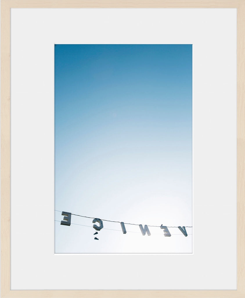 A minimal image from behind the Venice sign looking into the ombre sky and bright sunlight